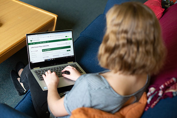 Student usign the uwgb libraries site on her laptop