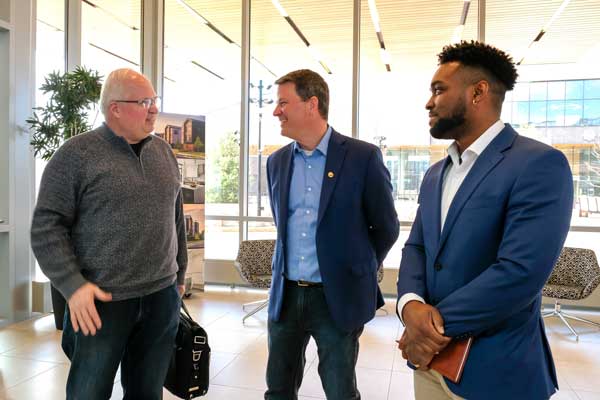 Student speaks with professors at business event