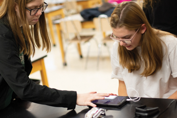Two students working on a project using an IPad