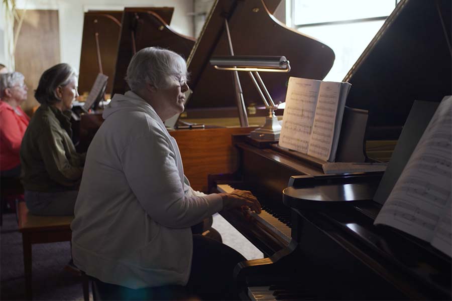 LLI members learning to play piano