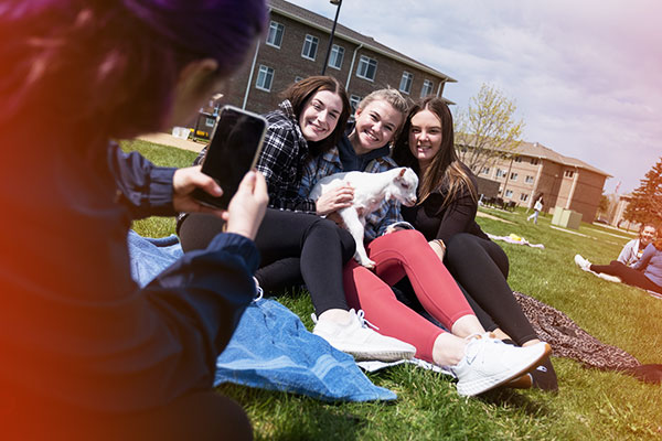 Students pose for a photo with a baby goat at a uwgb goat yoga event