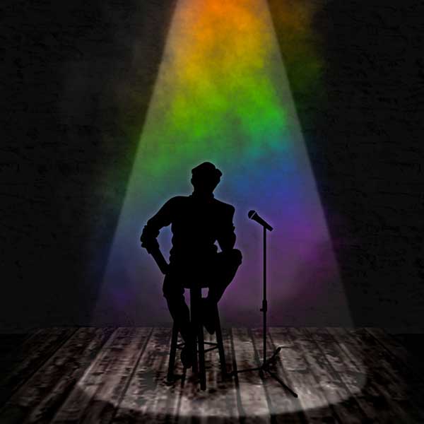 Sihlouette of a figure seated on a stool with a mic stand in a smokey rainbow colored spotlight