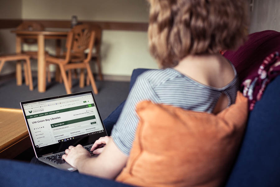 Student working on her laptop in a campus apartment