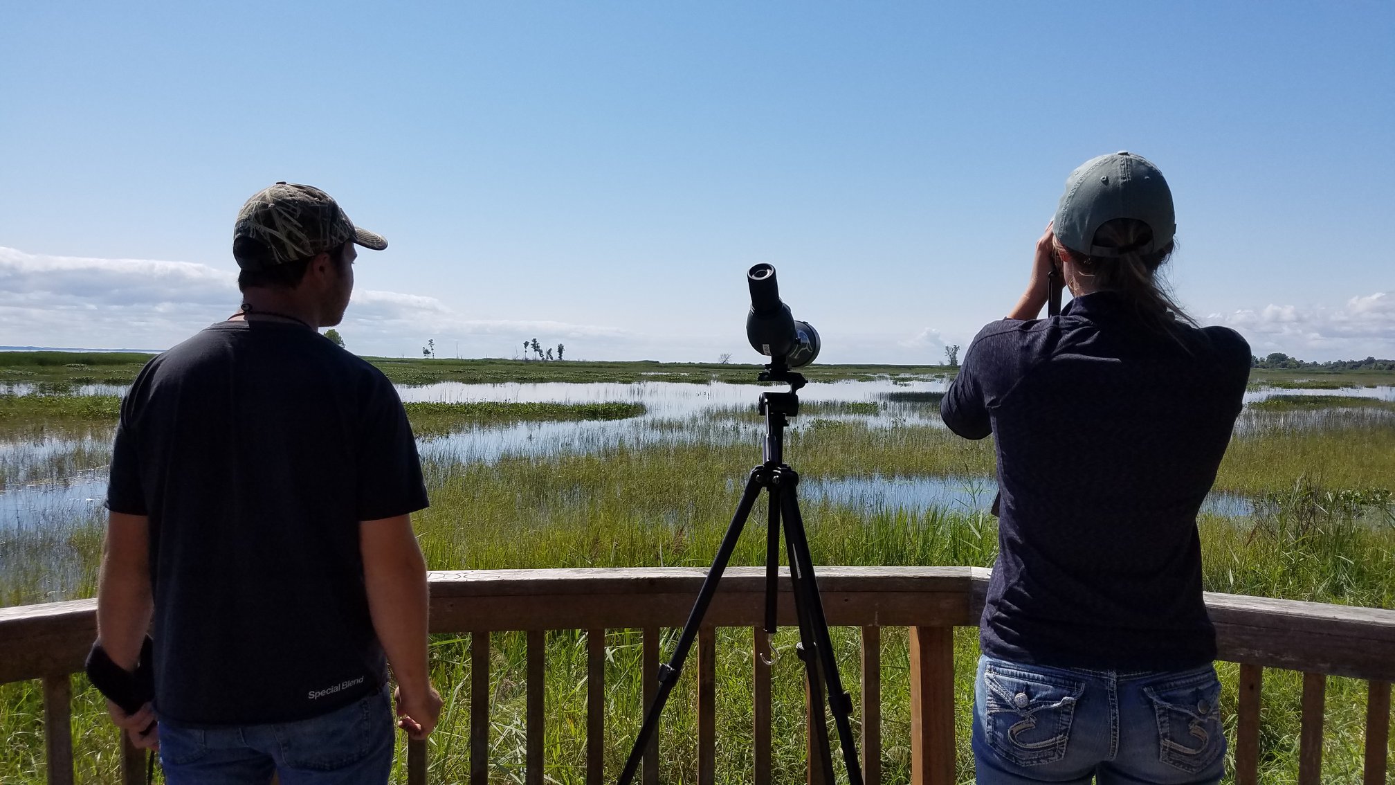 Two students looking into a field with binoculars