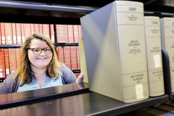 Student poses for photo in library