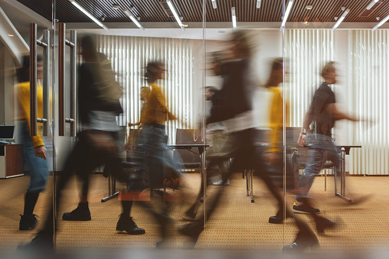 Motion Blurred People Walking Through Office