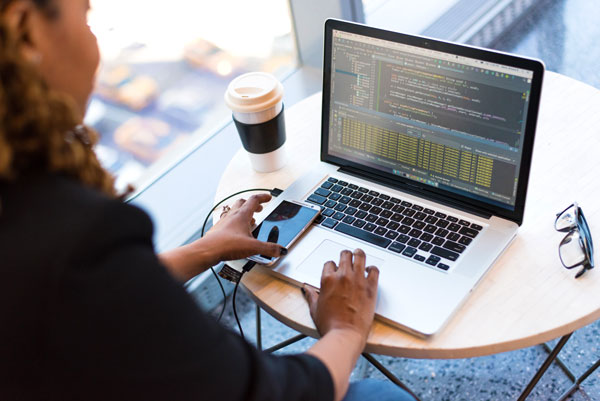 Female works at computer while drinking coffee