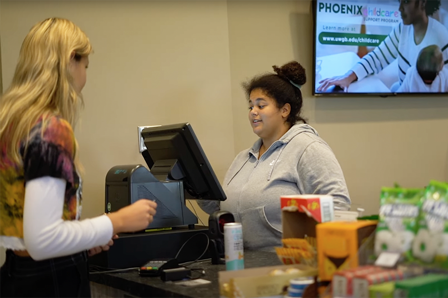 A student purchases a beverage at the Gardens Cafe