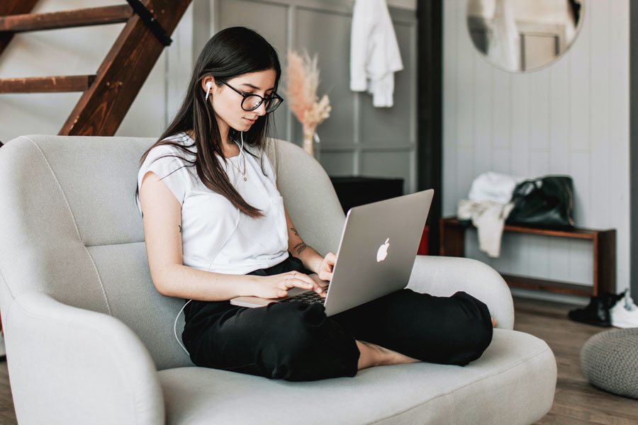 Woman wearing headphones attends class virtually