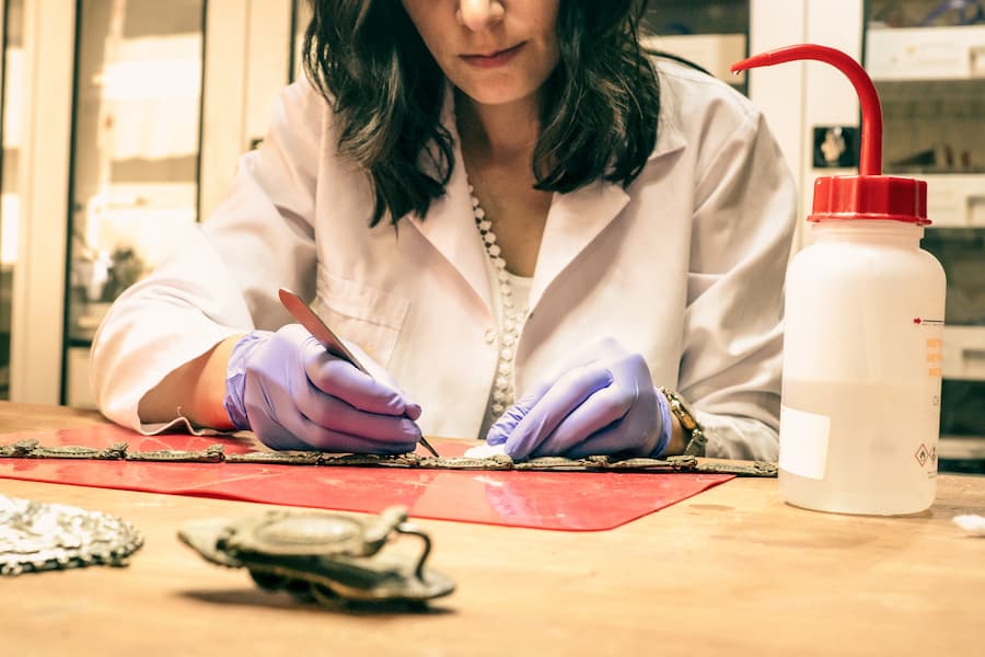 Archivist cleaning and restoring a historical artifact