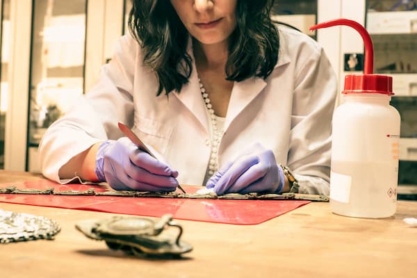 Historian cleaning and restoring artifacts