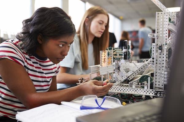 Two female students work on a mechanical engineering project