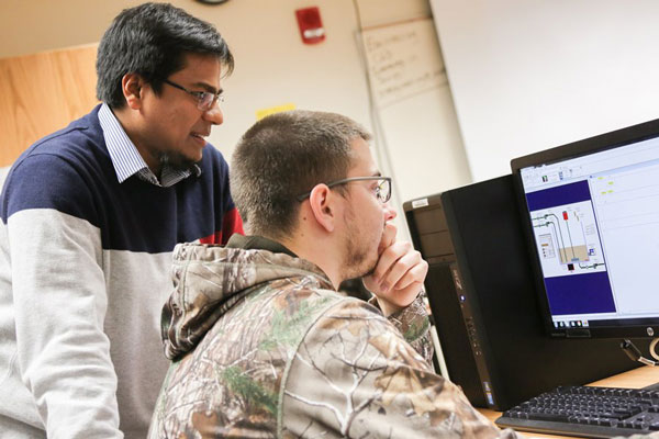 Professor and student looking at computer