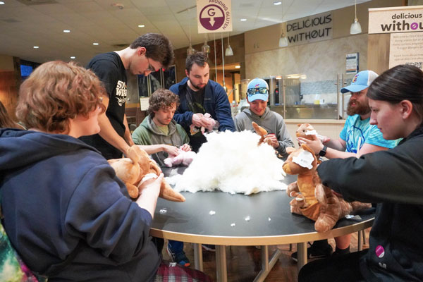 Groups of students stuff teddy bears during univeristy union event