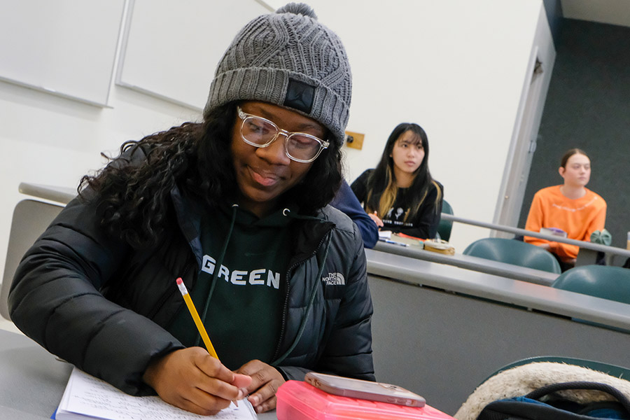 Student at desk, writing in notebook