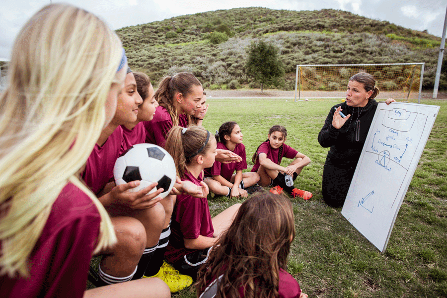 Woman coaching young girls soccer team