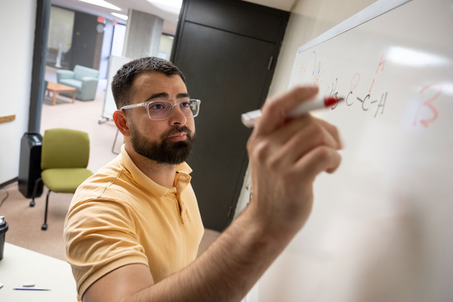 Adan Cordova writing equations on whiteboard