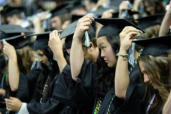 UWGB graduates moving their tassle from the right to the left to signify graduation