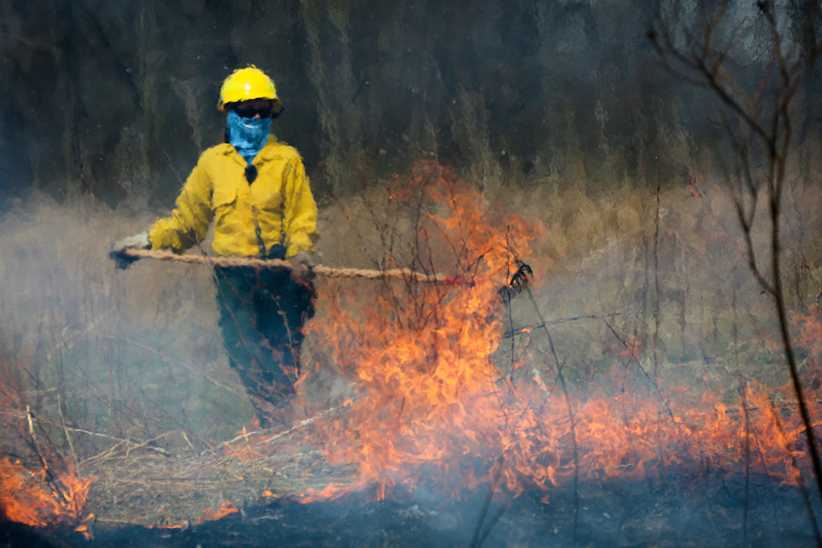 Person managing controlled prairie fire