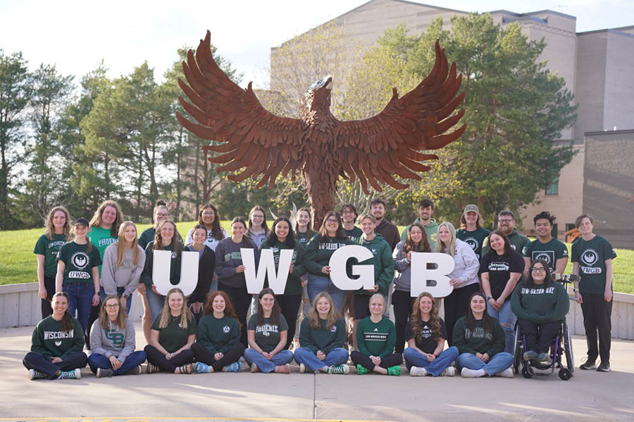 A group photo of Student Ambassadors in front of the Phoenix sculpture