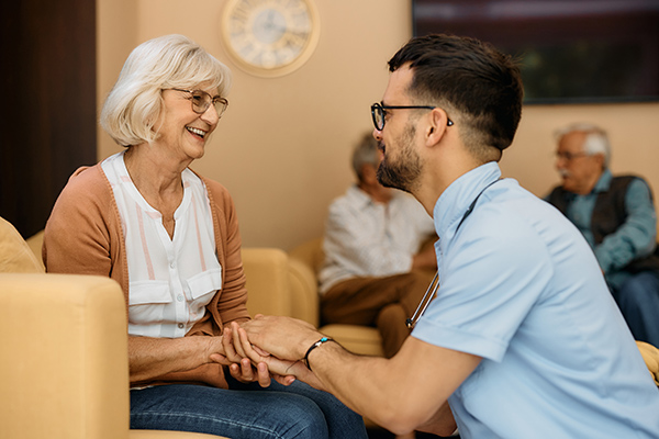 Young man caring for woman in assisted living