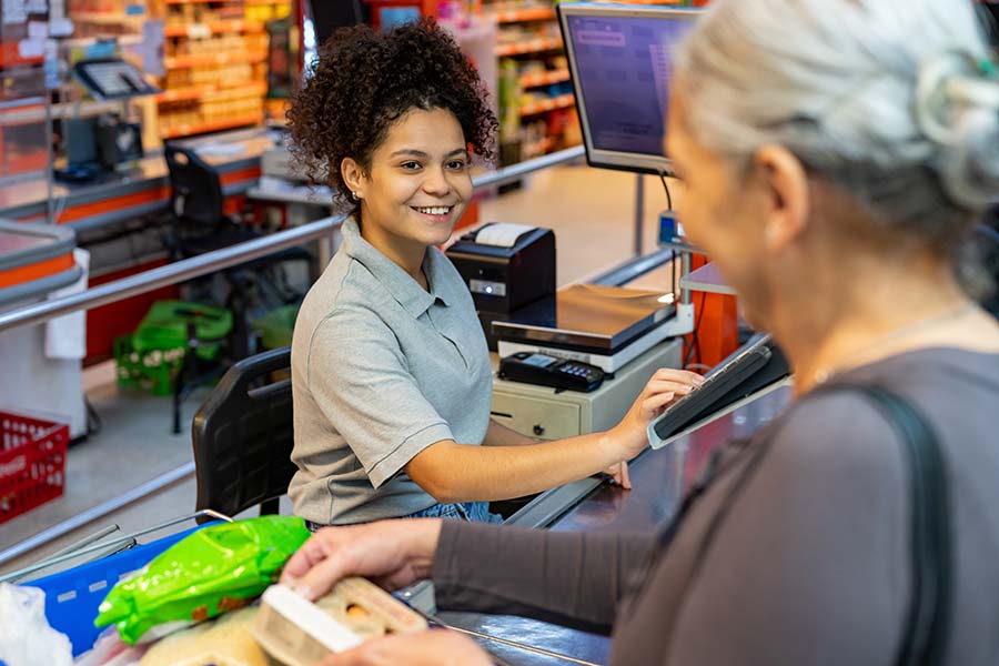 woman cashier checking out a customer at a grocery store