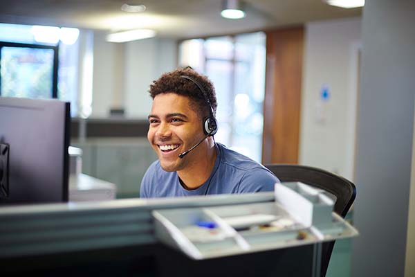 cheerful man with headset on working in call center