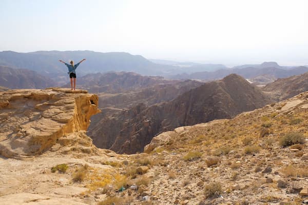 Person on moutain with arms out stretched