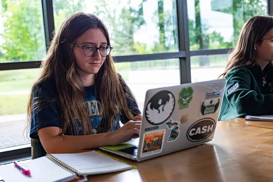 Student working with personal laptop on campus