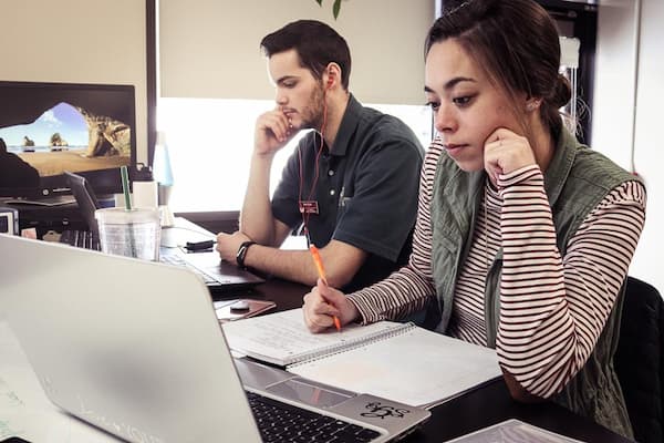 Two students studying at laptops