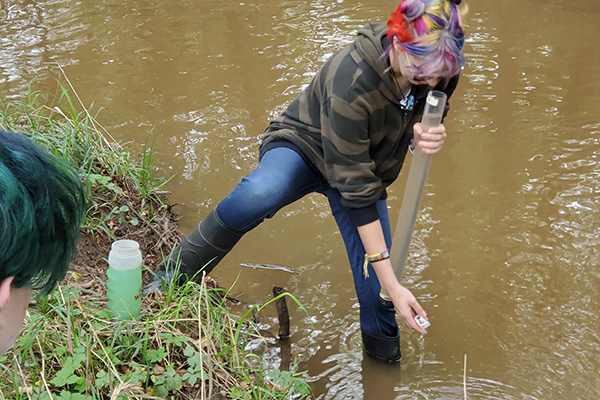 Student testing creek water