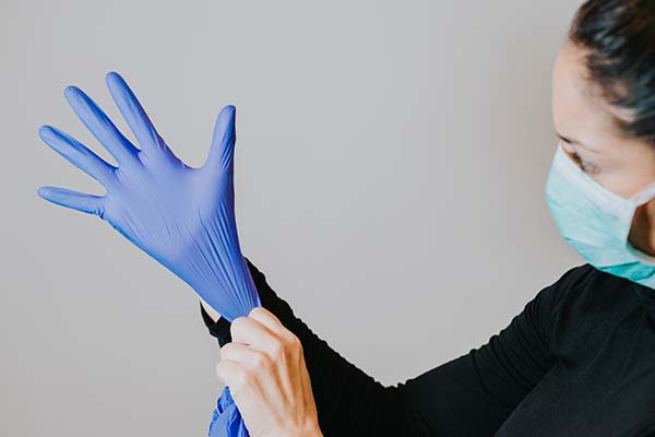 woman putting on gloves