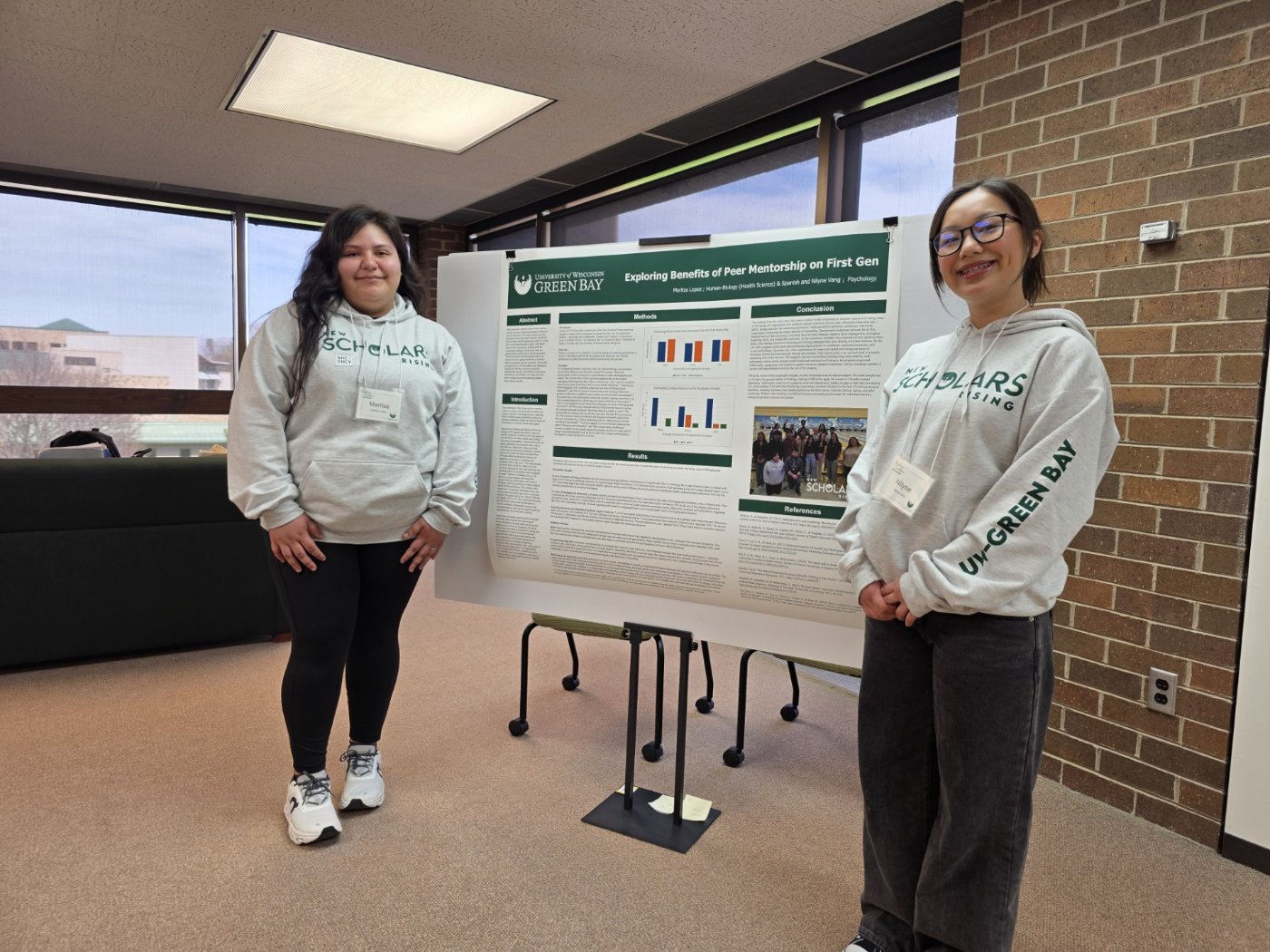 Two female students standing in front of an information board