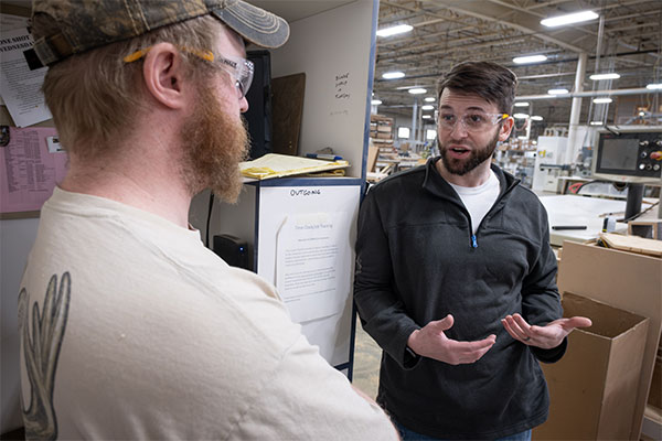 UW-Green Bay alumnus Michael Becker speaks with co-workers at the Central Wisconsin Woodworking Corporation in Wausau, Wisconsin