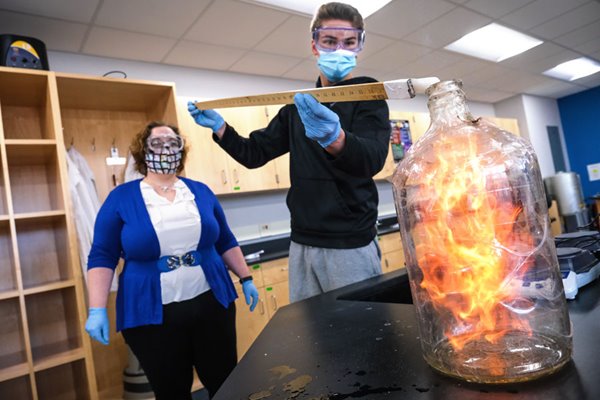 Professor and student perform experiment in lab