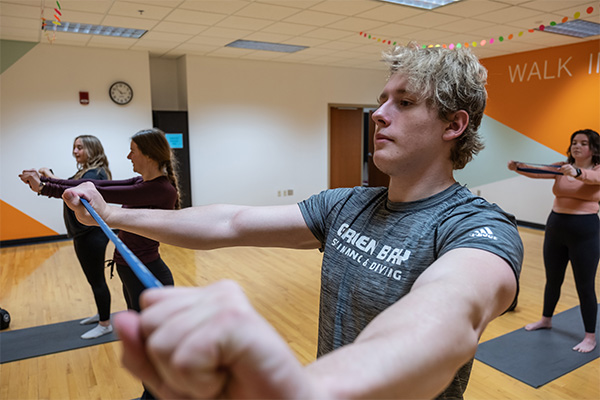 UWGB group exercise class using resistance bands for arm strength