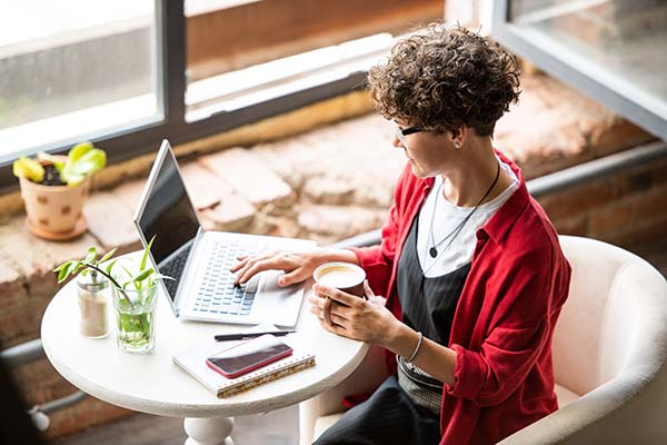 woman enjoying coffee while attending virtual session