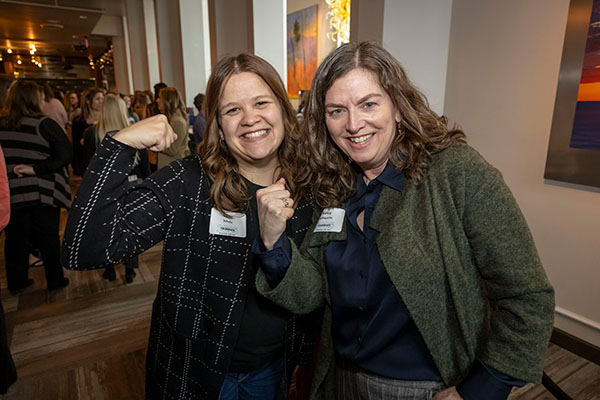 two women making the Accelerate Action pose