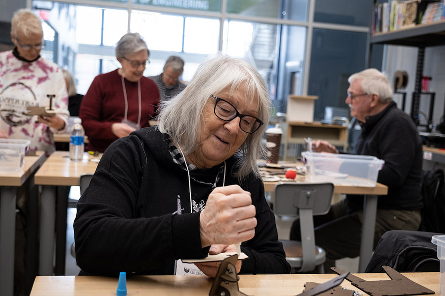 Senior woman working on art project in class