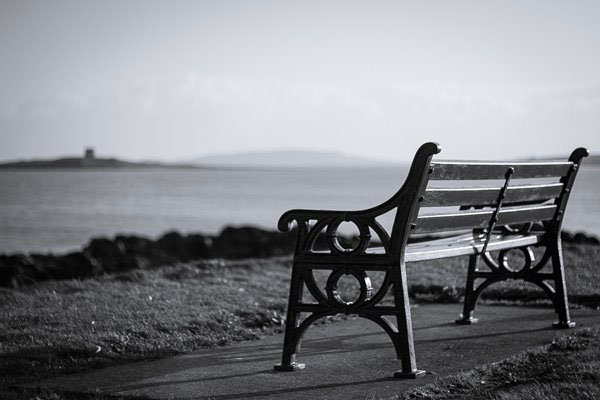 Empty bench by the water