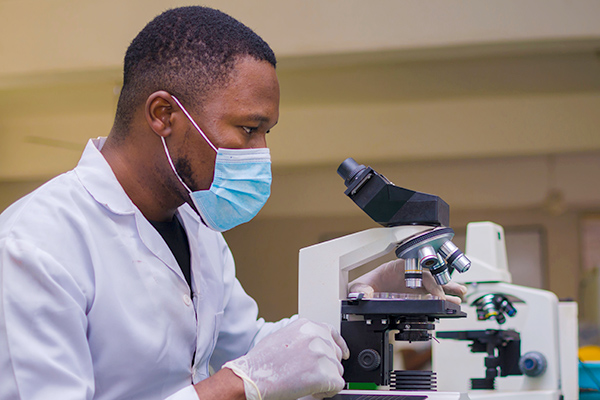 Male student working with lab microscope