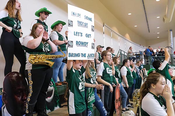 Pep band students cheering with signs