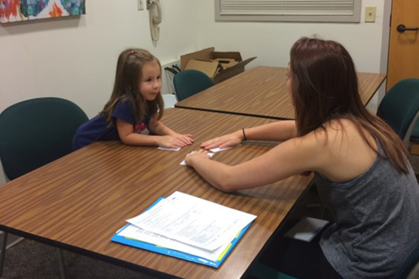 Researcher playing a study game with young girl