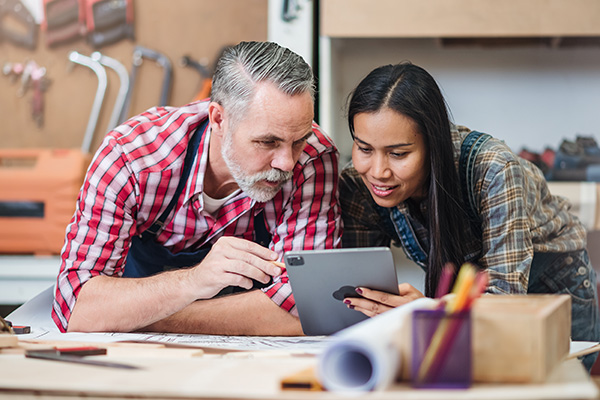 Older man and young woman collaborating on ipad