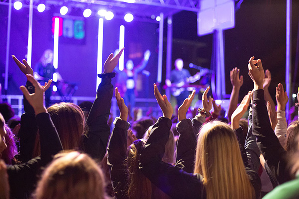 Concert-goers in front of lit stage