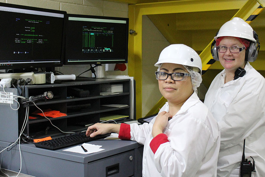 two women wearing protective gear in manufacturing facility