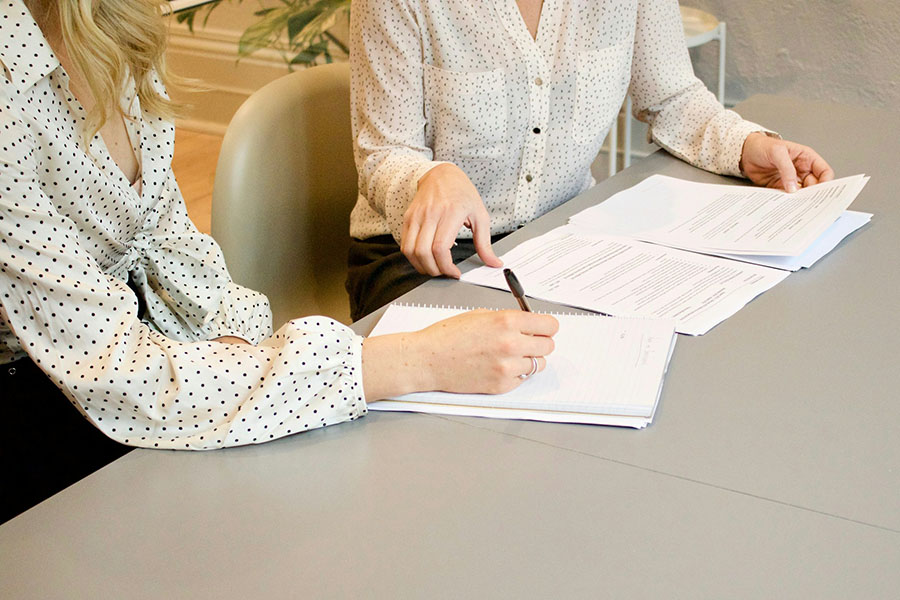 two people looking at sheets of paper together