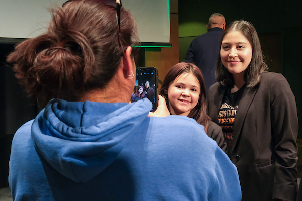 Young child takes photo with guest speaker and star of "Echo" Alaqua Cox