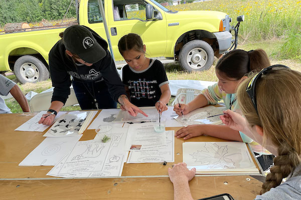 Campers drawing leaves outdoors