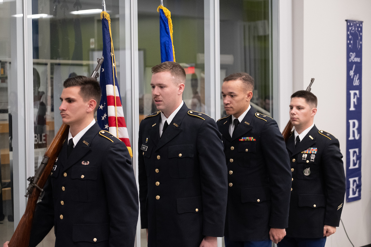 Veterans in uniform carrying flag 